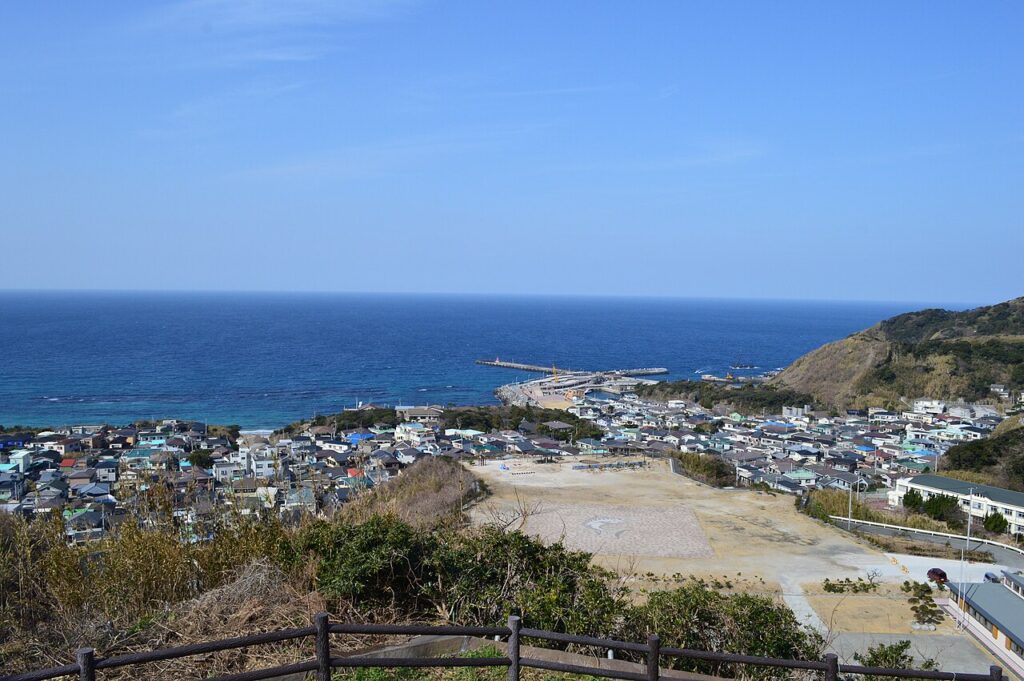 Scenic view of Kōzushima Island’s coastline with clear blue water and lush green cliffs, one of Tokyo’s remote island escapes.